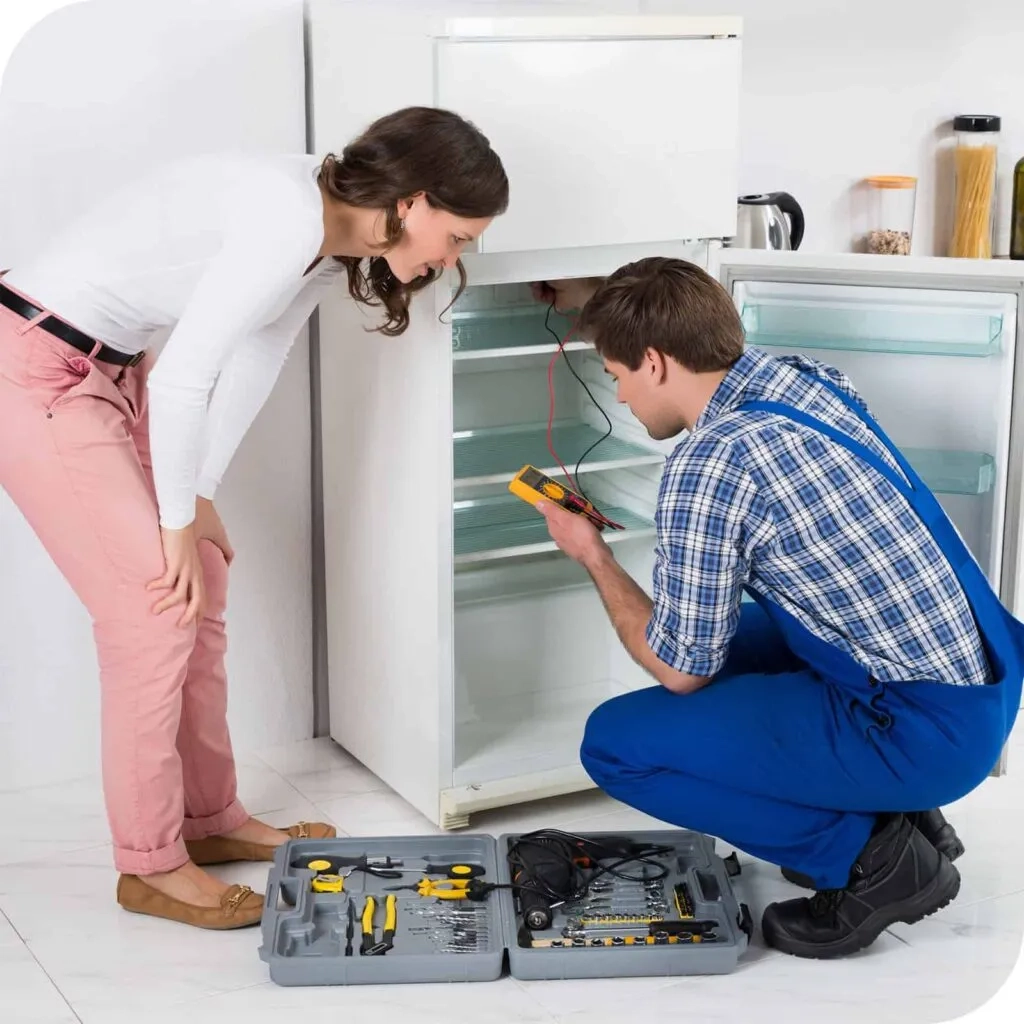 RightFix technician testing a refrigerator while the customer looks on