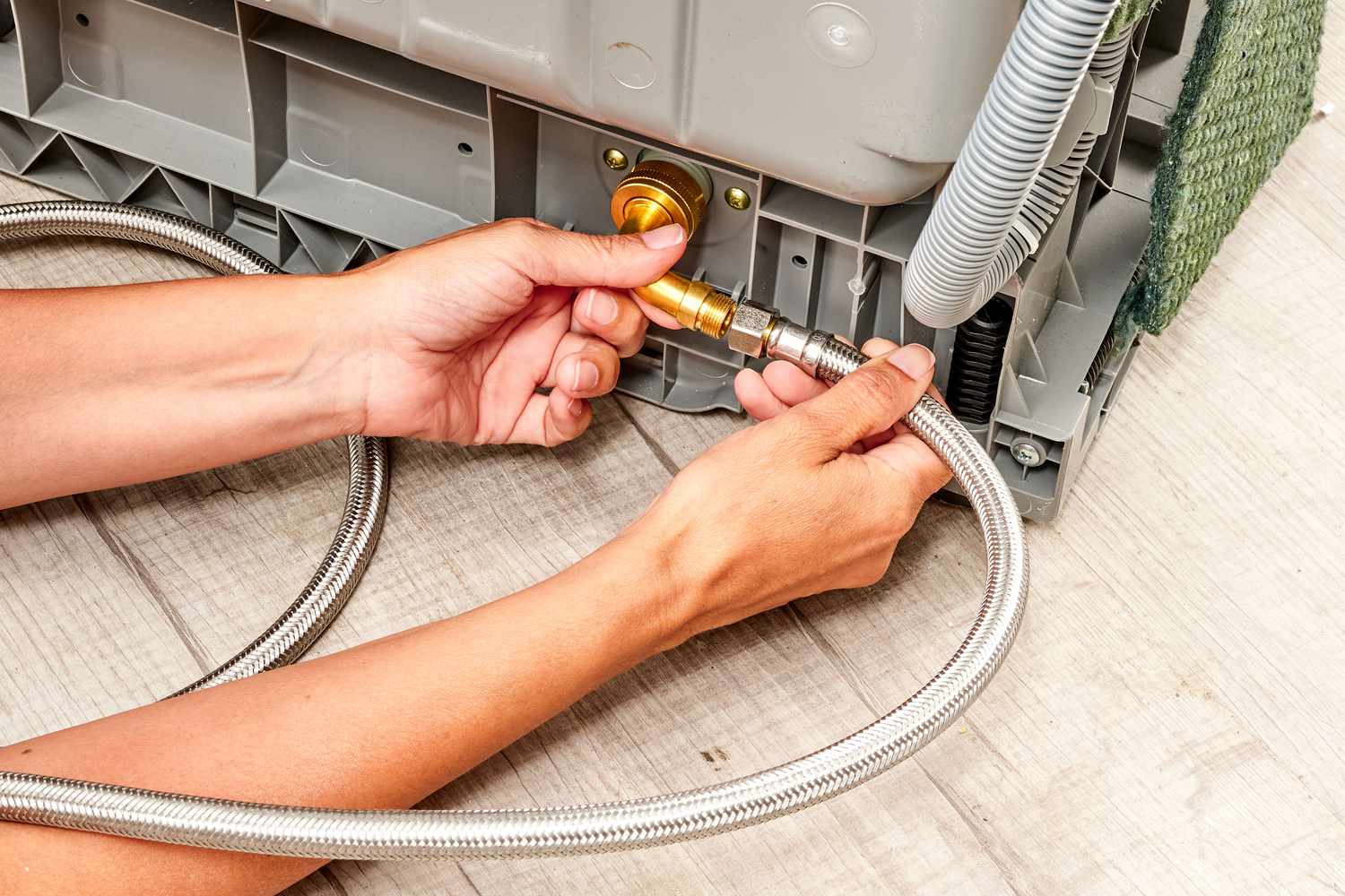 A technician examining a dishwasher water inlet valve for damage