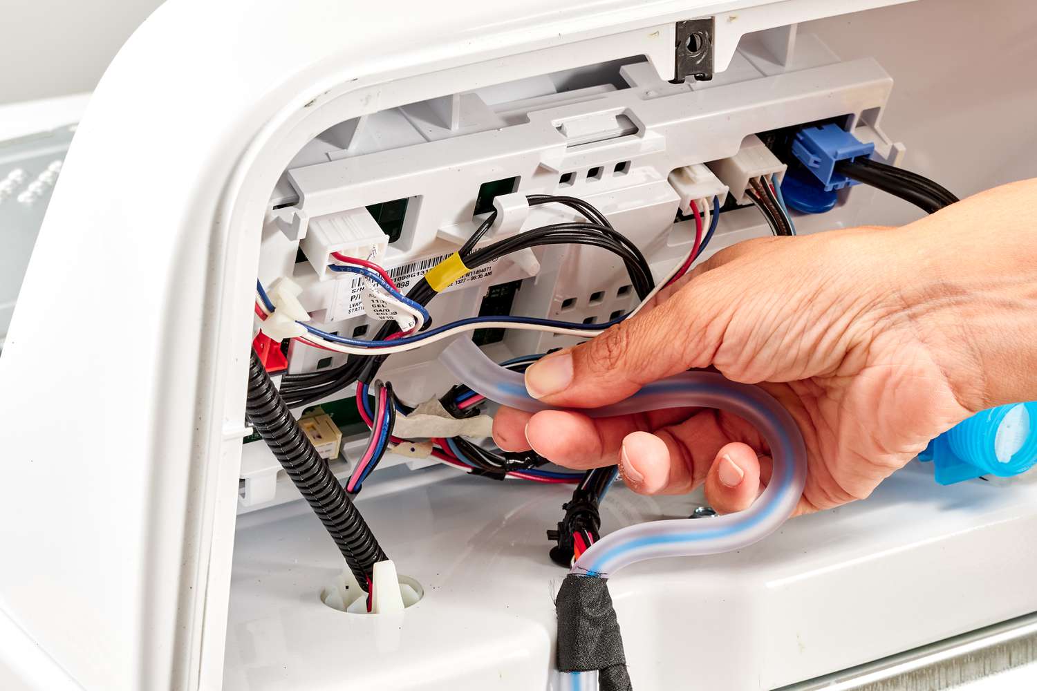 Close-up of a technician testing a dishwasher water level sensor