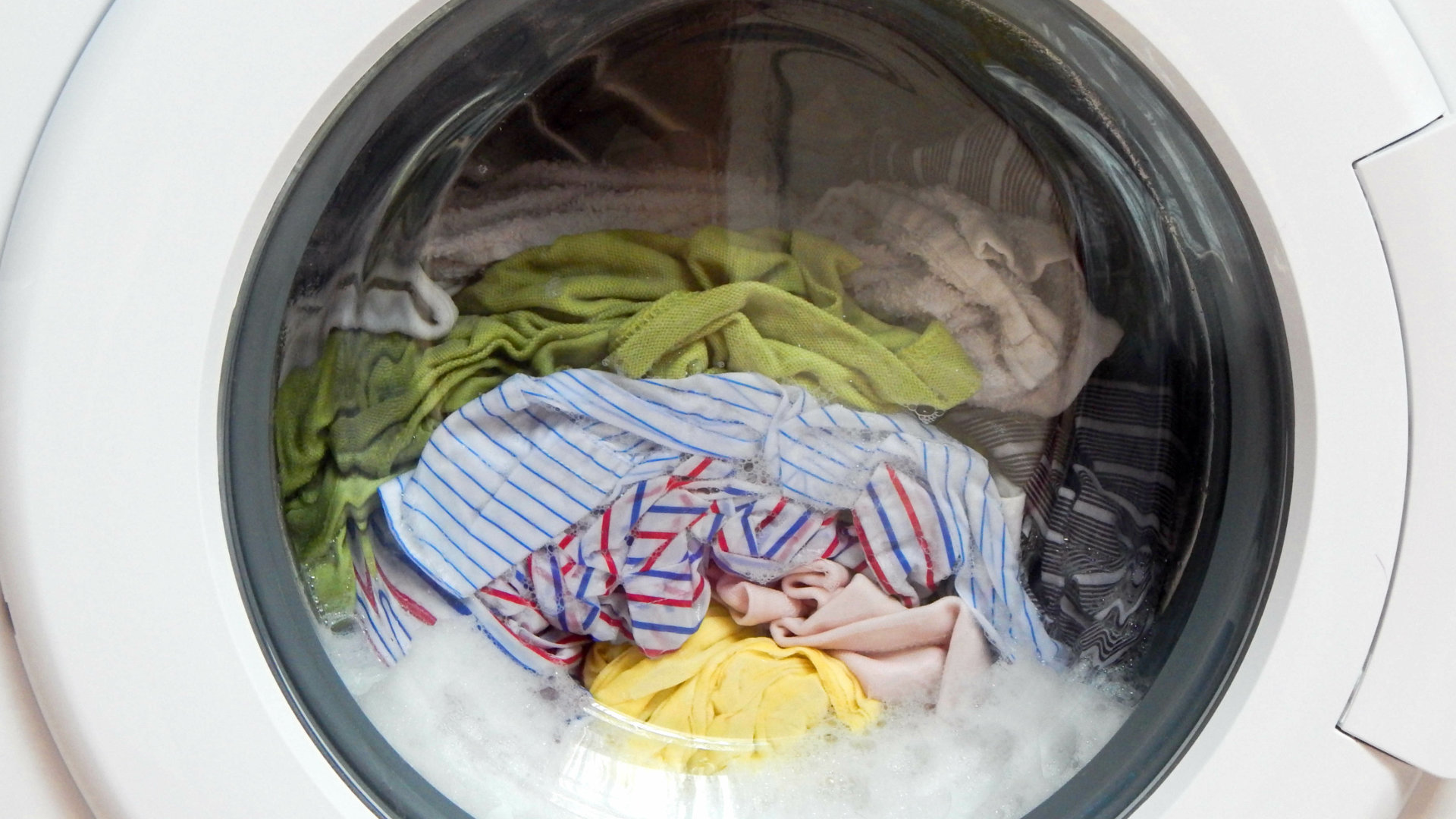 Washing machine with clothes still wet after the spin cycle, causing longer drying times in the dryer