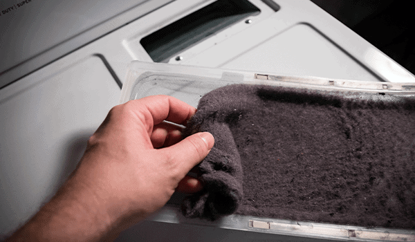 Clogged dryer lint screen with buildup of dust and lint, blocking airflow and increasing drying time