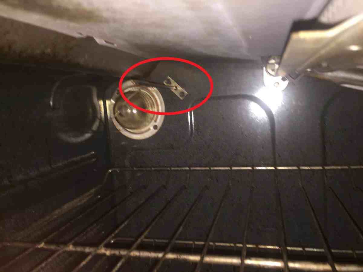 Close-up of a technician checking the temperature sensor inside a Frigidaire oven