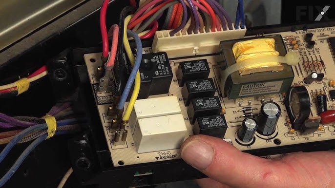 Technician replacing the electronic oven control board in a Frigidaire oven